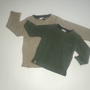 Maglia verde e beige a maniche lunghe per bambini con bottoni in legno e tasca, perfetta per un look comodo ed elegante.
