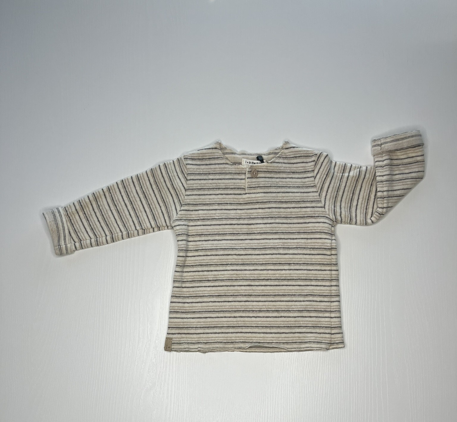 Maglia a righe beige e grigie per bambini con maniche lunghe.
