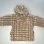 Morbido cappotto in pile a quadri beige e bianchi per neonati, con cappuccio e piedini integrati.