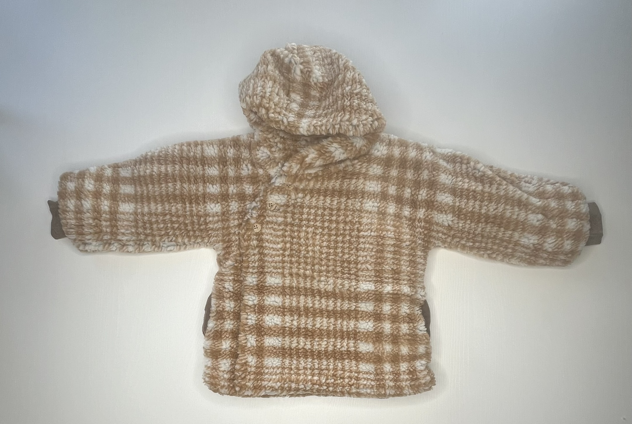 Morbido cappotto in pile a quadri beige e bianchi per neonati, con cappuccio e piedini integrati.