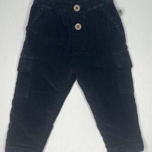 Pantaloni blu per bambino a costine in velluto con tasche laterali alle gambe e chiusura a bottone.