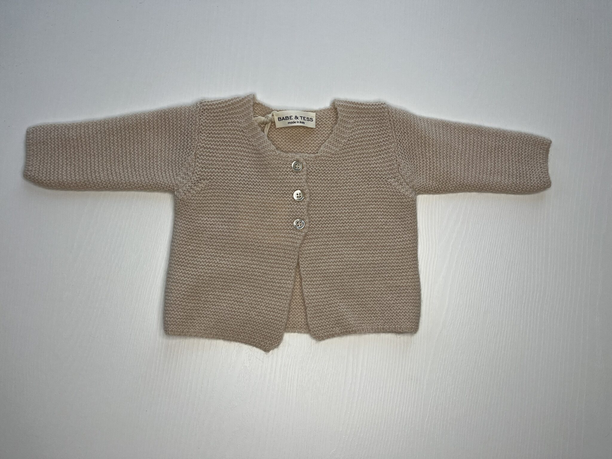 Cardigan beige in maglia per bambini con bottoni, caldo e morbido, perfetto per le stagioni fredde.