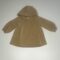 Abito per bambina color beige con cappuccio e maniche lunghe.